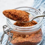 Spoonful of blackened seasoning resting on open jar