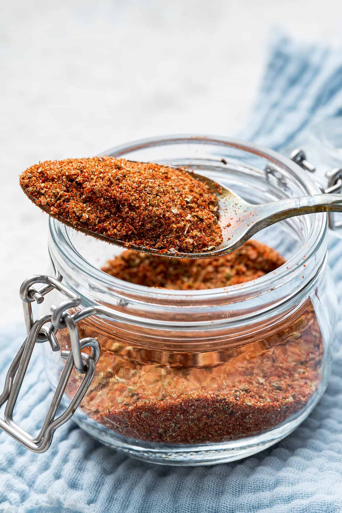 Spoonful of blackened seasoning resting on open jar