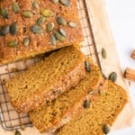 Overhead view of vegan pumpkin bread loaf with 3 slices cut