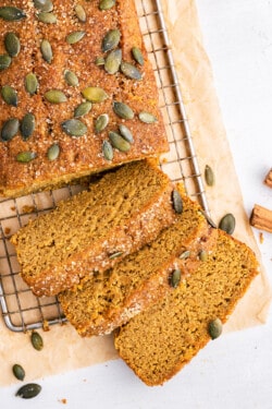 Overhead view of vegan pumpkin bread loaf with 3 slices cut