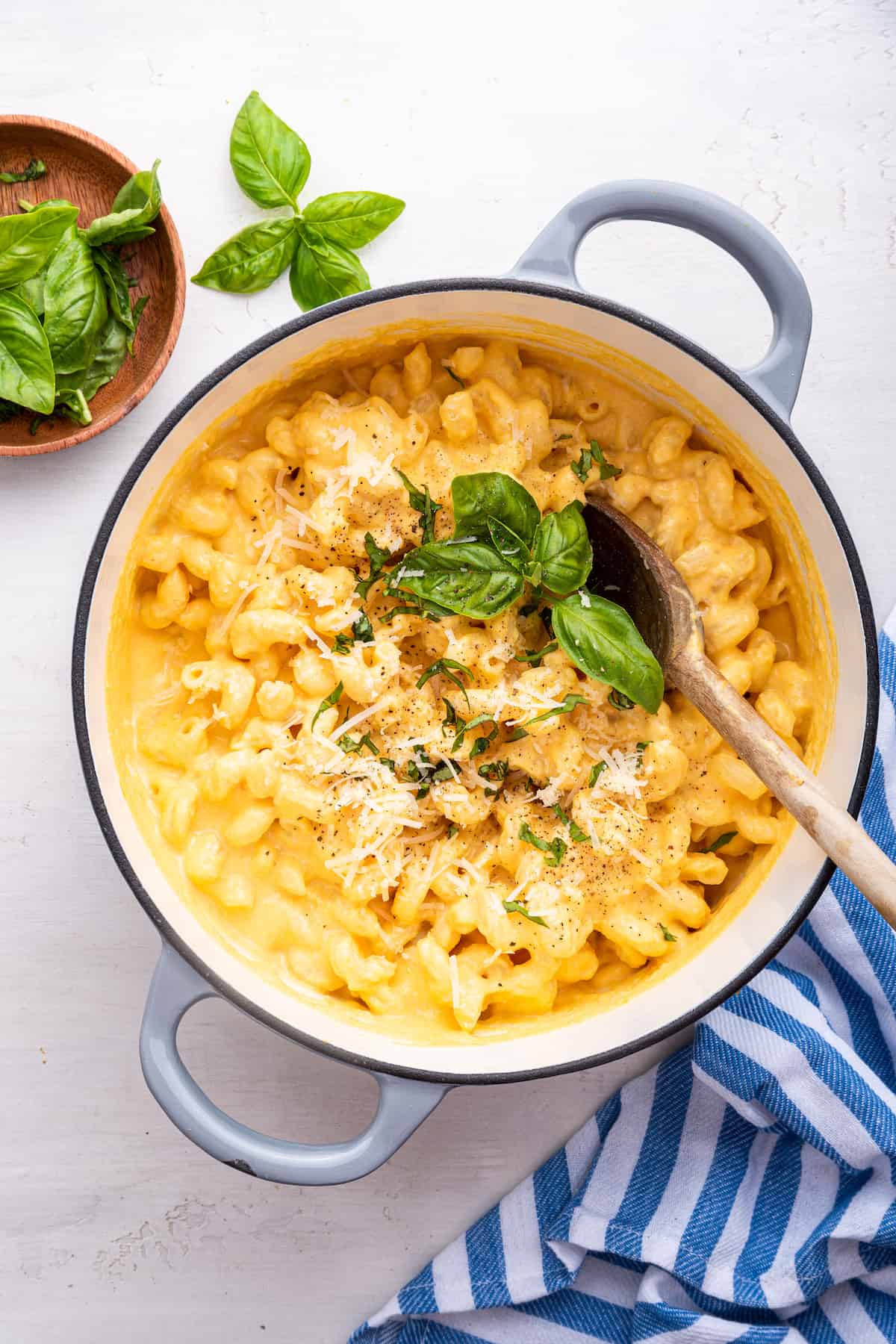 Overhead view of butternut mac and cheese in Dutch oven with wooden spoon