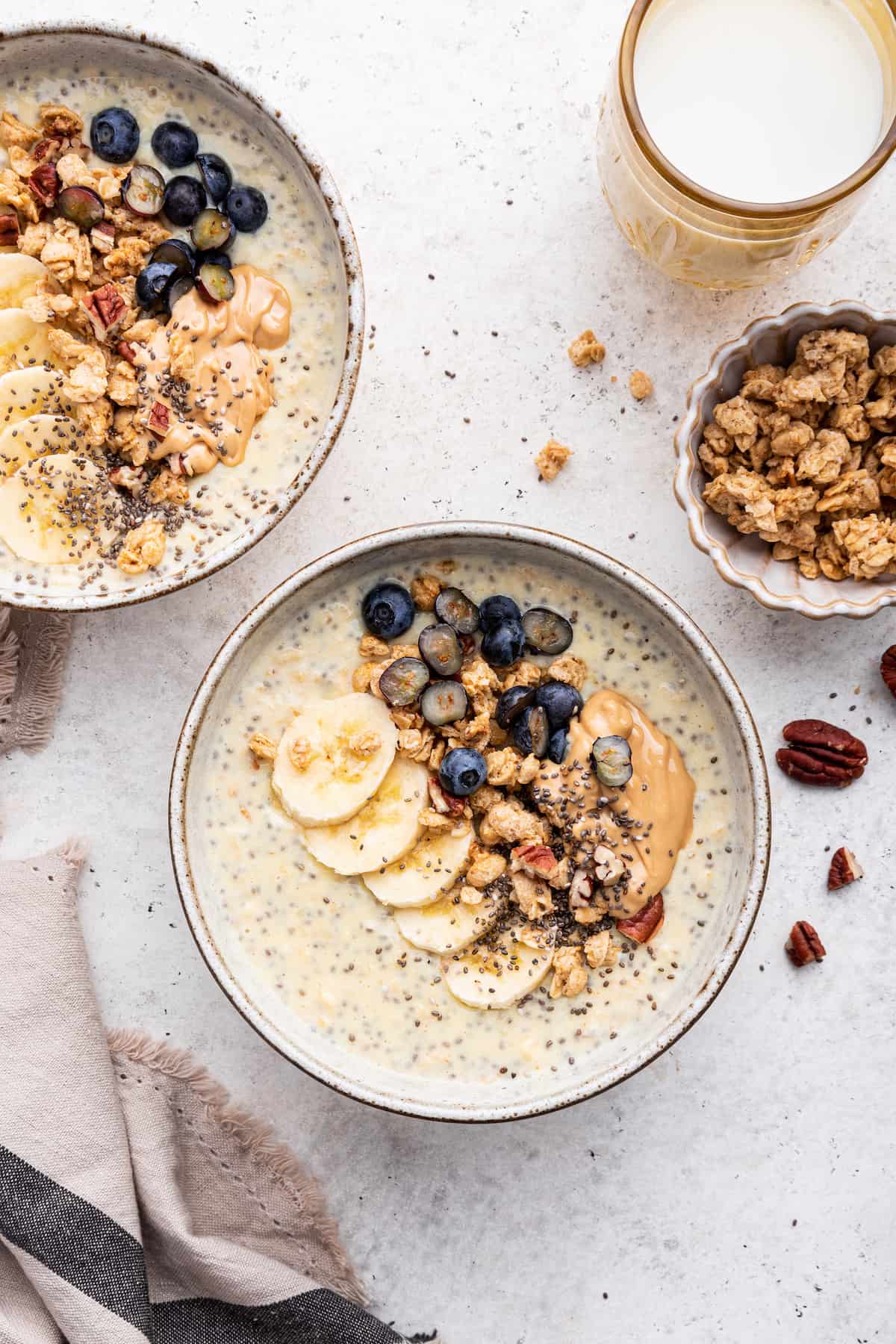 Overhead view of two bowls of protein oatmeal with toppings