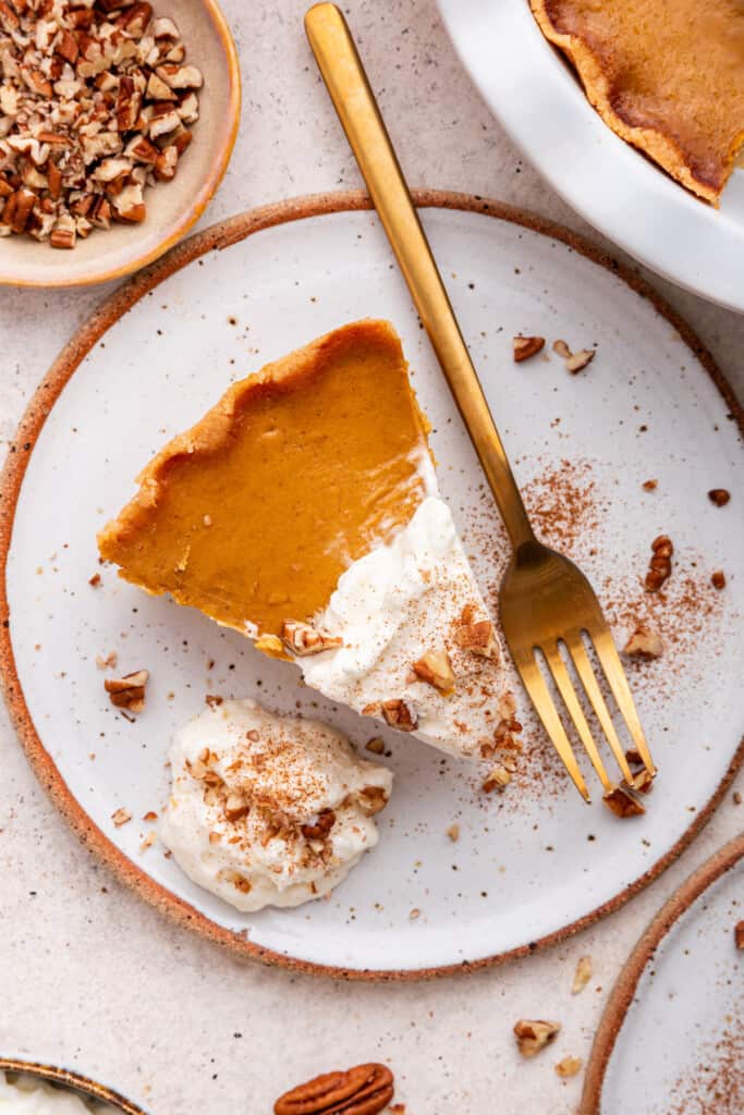 Overhead view of gluten-free pumpkin pie on plate with gold fork