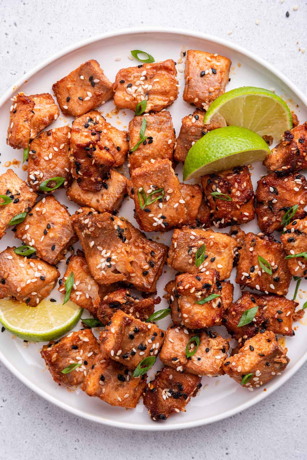 Plate of air fryer salmon bites with lime wedges