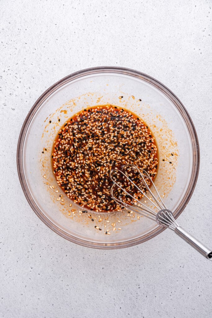 Overhead view of marinade in bowl with whisk