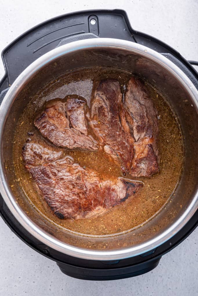 Overhead view of chuck roast added to Instant Pot