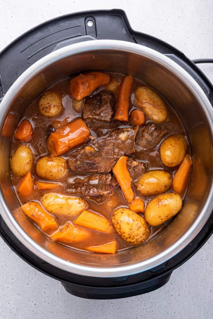 Overhead view of chuck roast, carrots, and potatoes in Instant Pot
