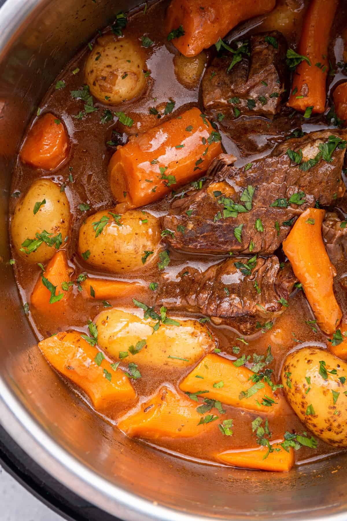 Overhead view of chuck roast, potatoes, and carrots in Instant Pot