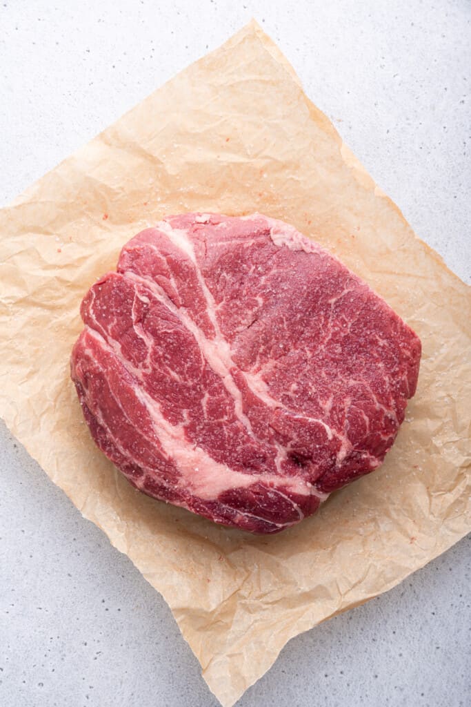 Overhead view of whole chuck roast on parchment paper