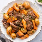 Overhead view of Instant Pot chuck roast with potatoes and carrots on plate with parsley