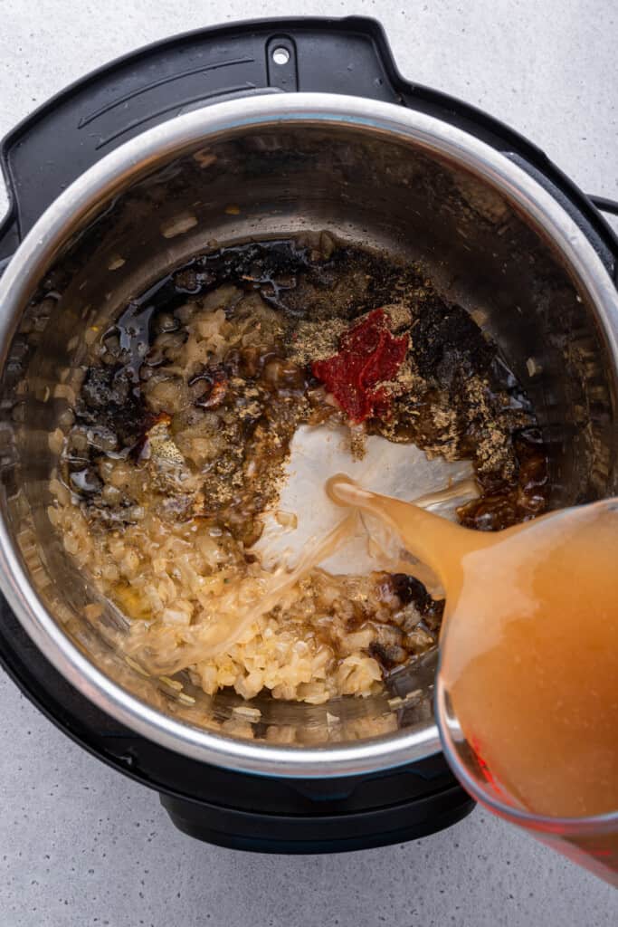 Overhead view of broth being poured into Instant Pot