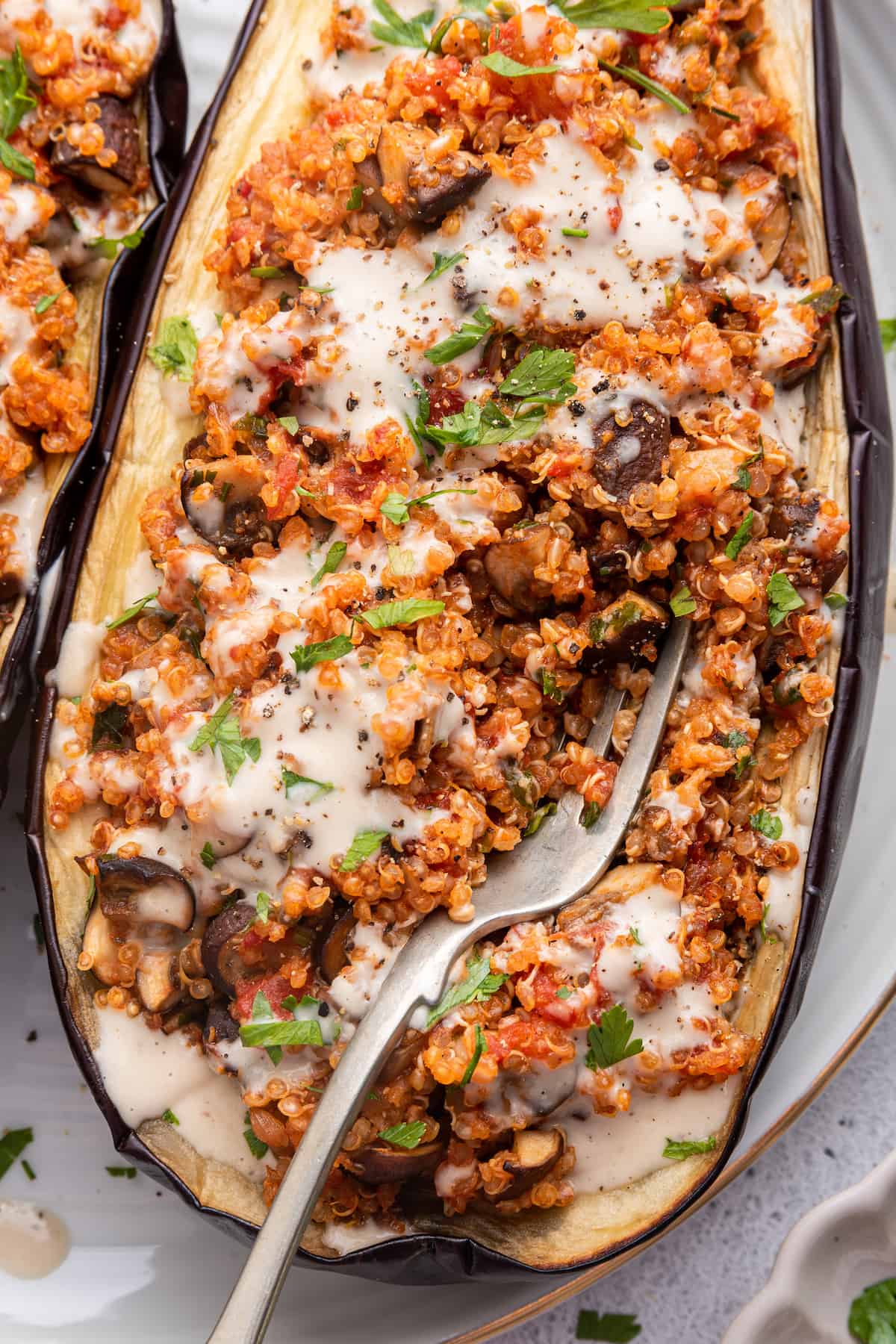 Closeup of fork digging into stuffed eggplant