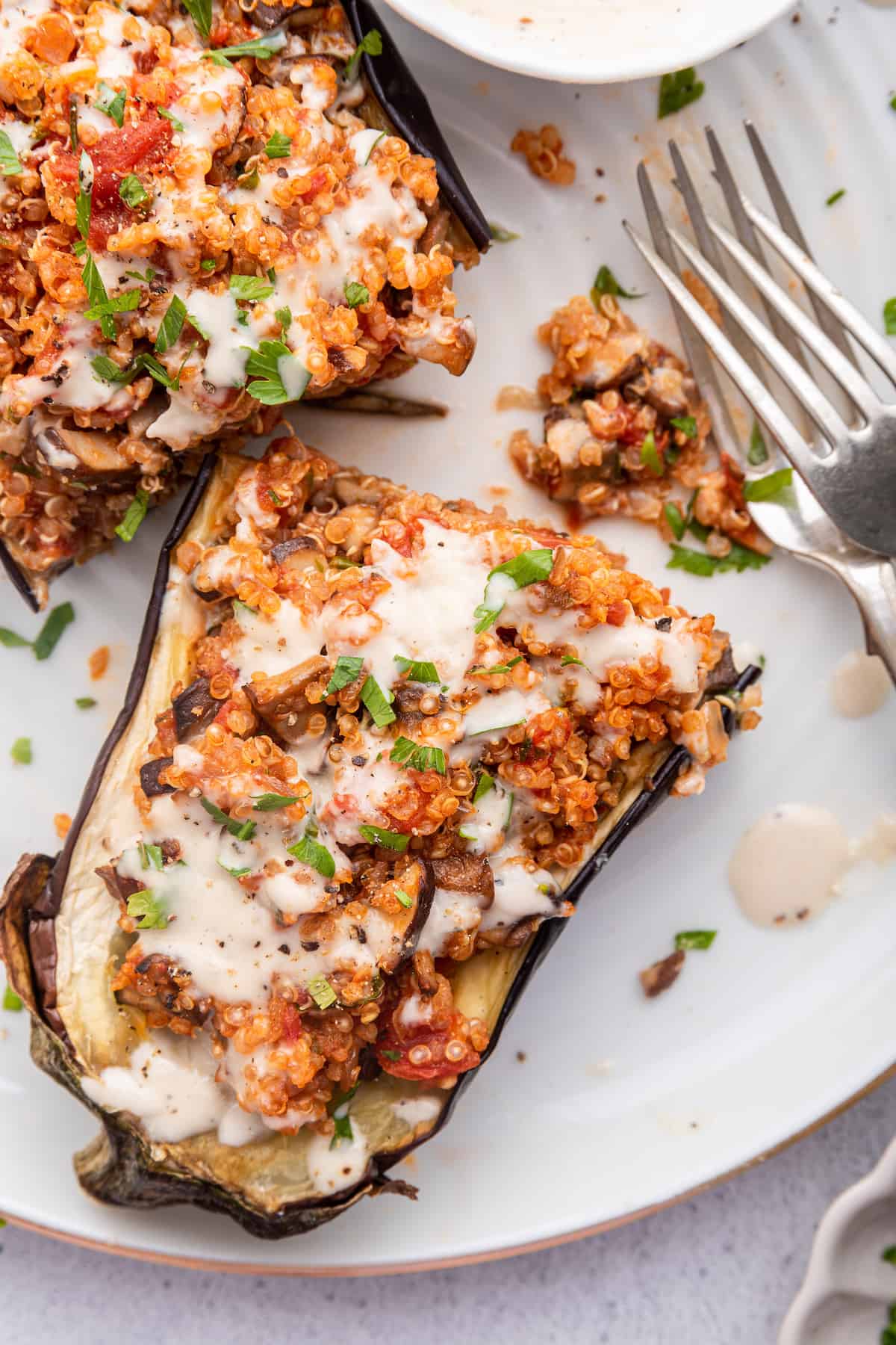 Overhead view of stuffed eggplant on plate with tahini drizzle