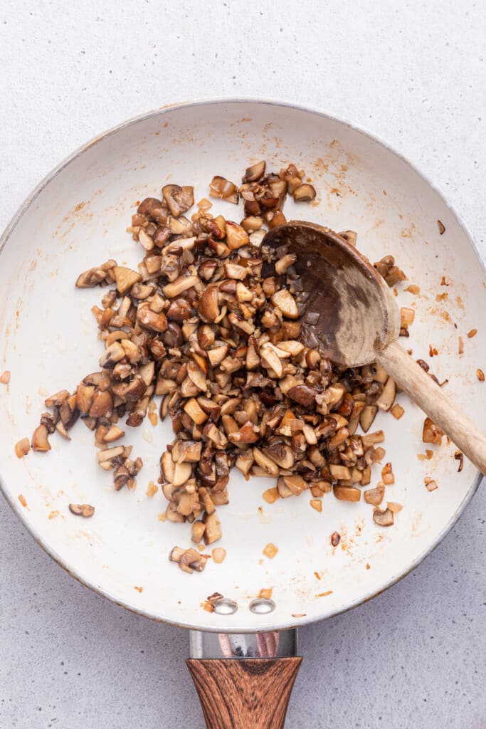 Overhead view of mushrooms being sauteed in skillet