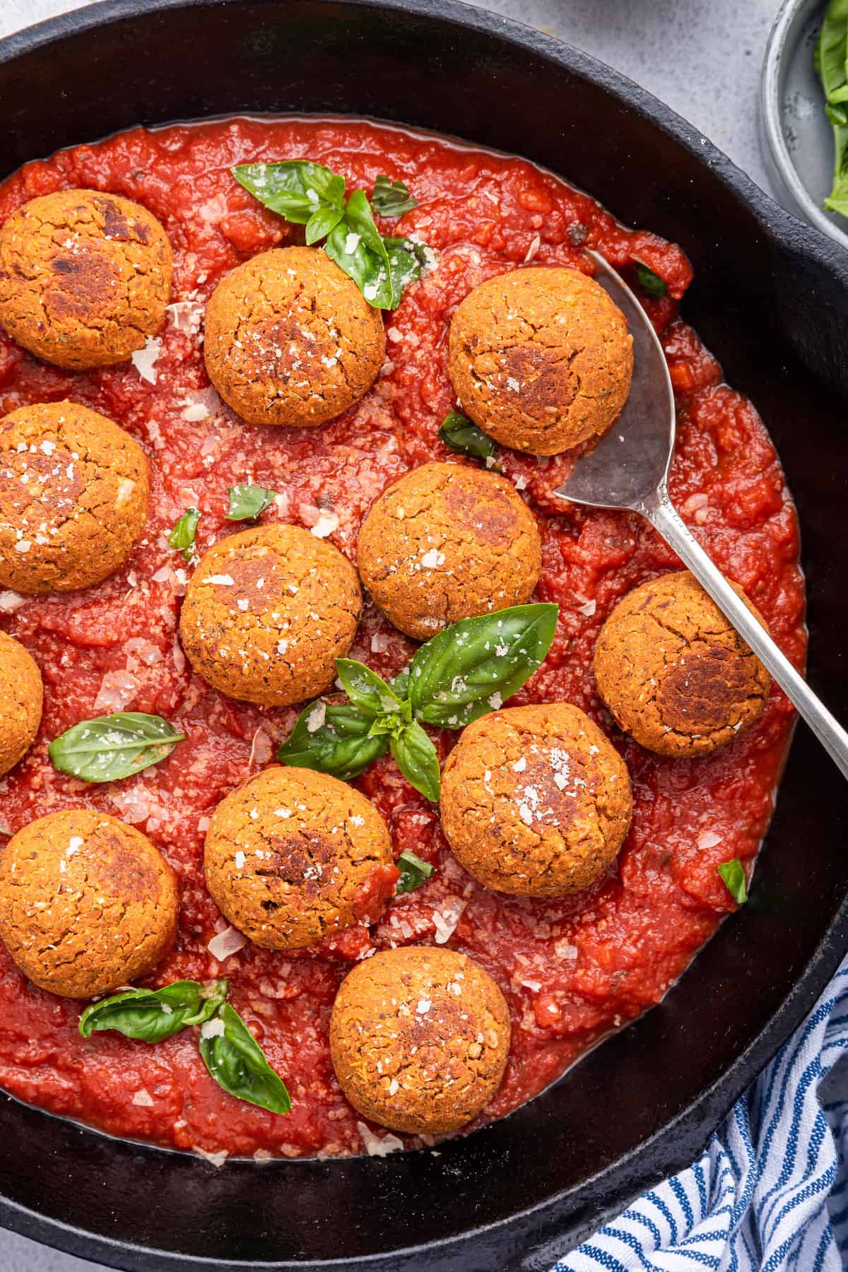 Overhead view of vegan meatballs in skillet of tomato sauce