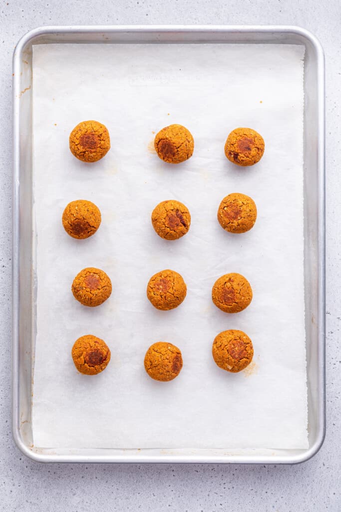 Overhead view of baked vegan meatballs on sheet pan