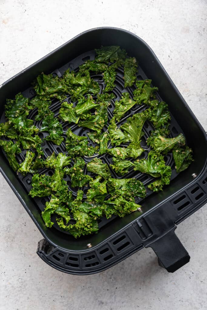Overhead view of raw kale in air fryer