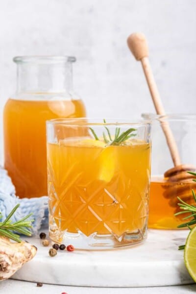 Fire cider in glass with sprig of rosemary and lemon slice