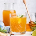 Fire cider in glass with sprig of rosemary and lemon slice