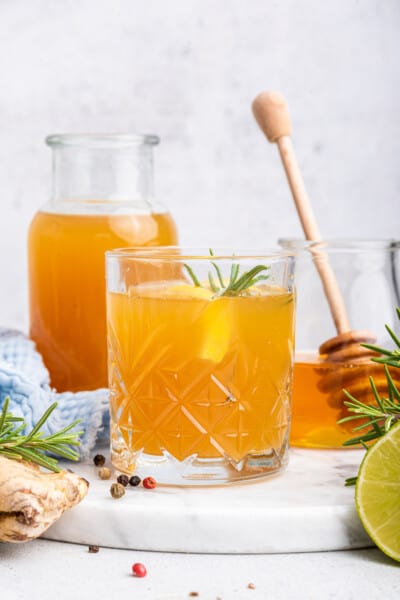 Fire cider in glass with sprig of rosemary and lemon slice