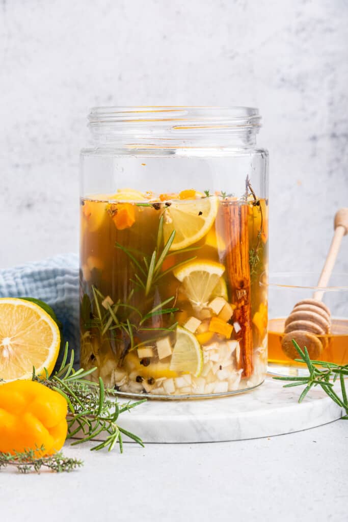 Fire cider ingredients in jar after pouring in vinegar