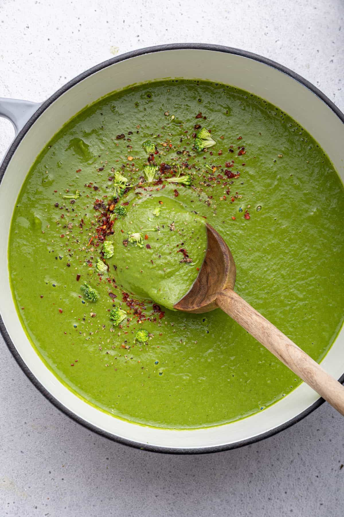 Overhead view of detox soup in pot with wooden spoon