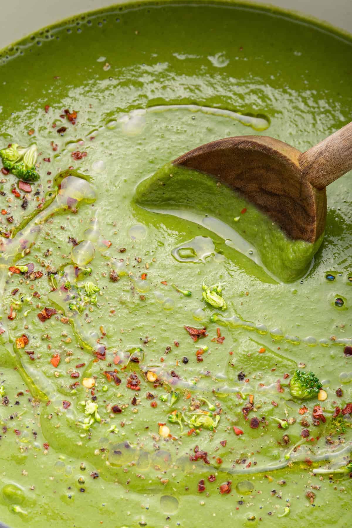 Stirring detox soup in pot with wooden spoon