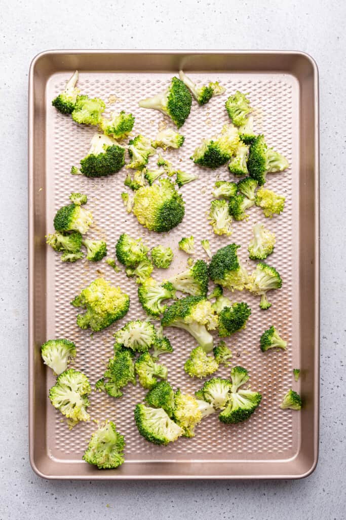 Overhead view of raw broccoli on sheet pan