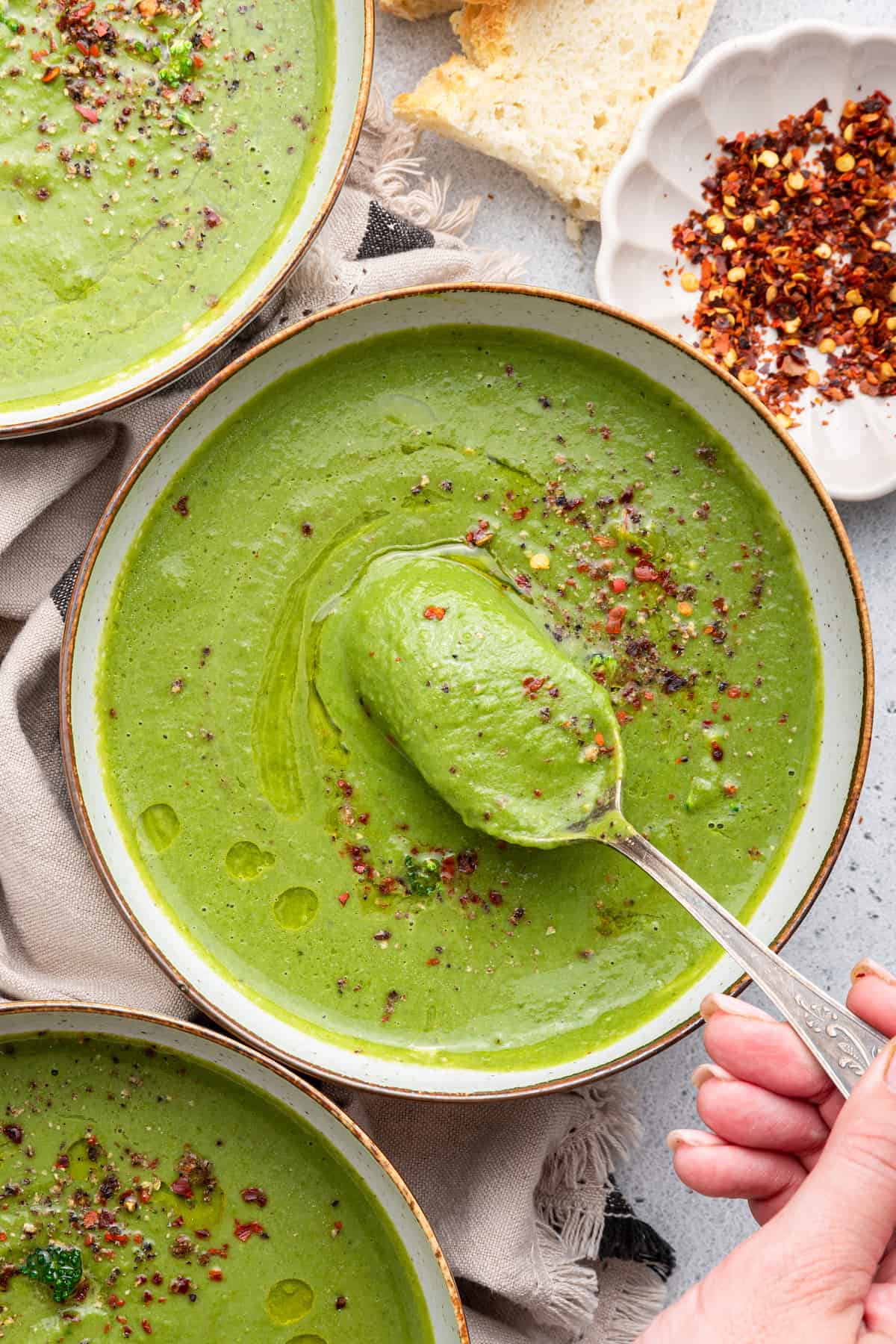 Overhead view of spoonful of detox soup held over bowl