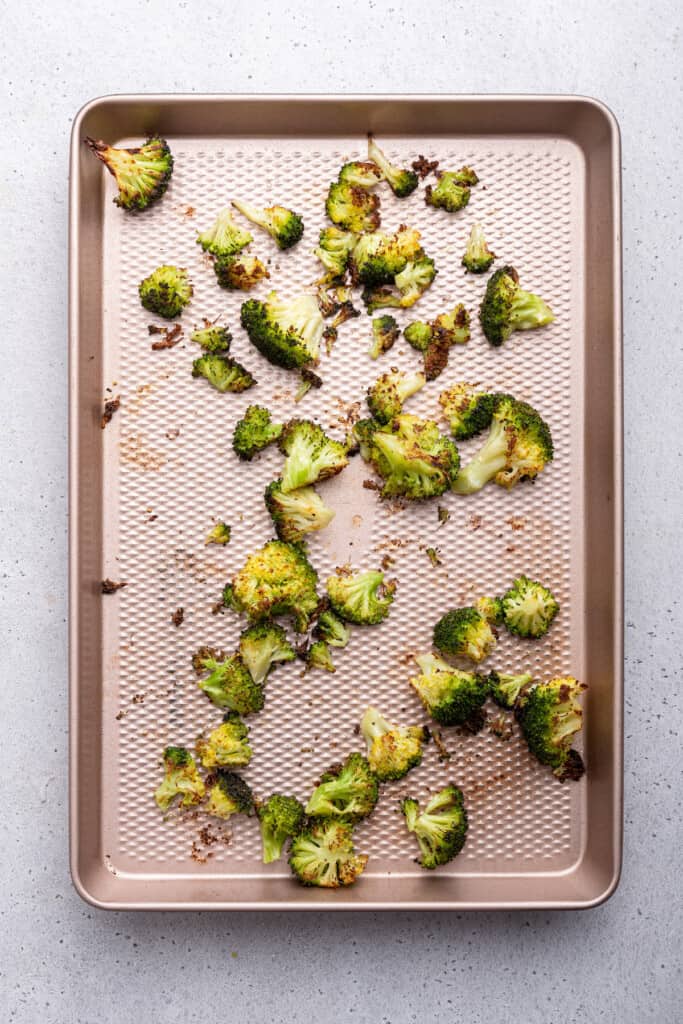 Overhead view of roasted broccoli on sheet pan