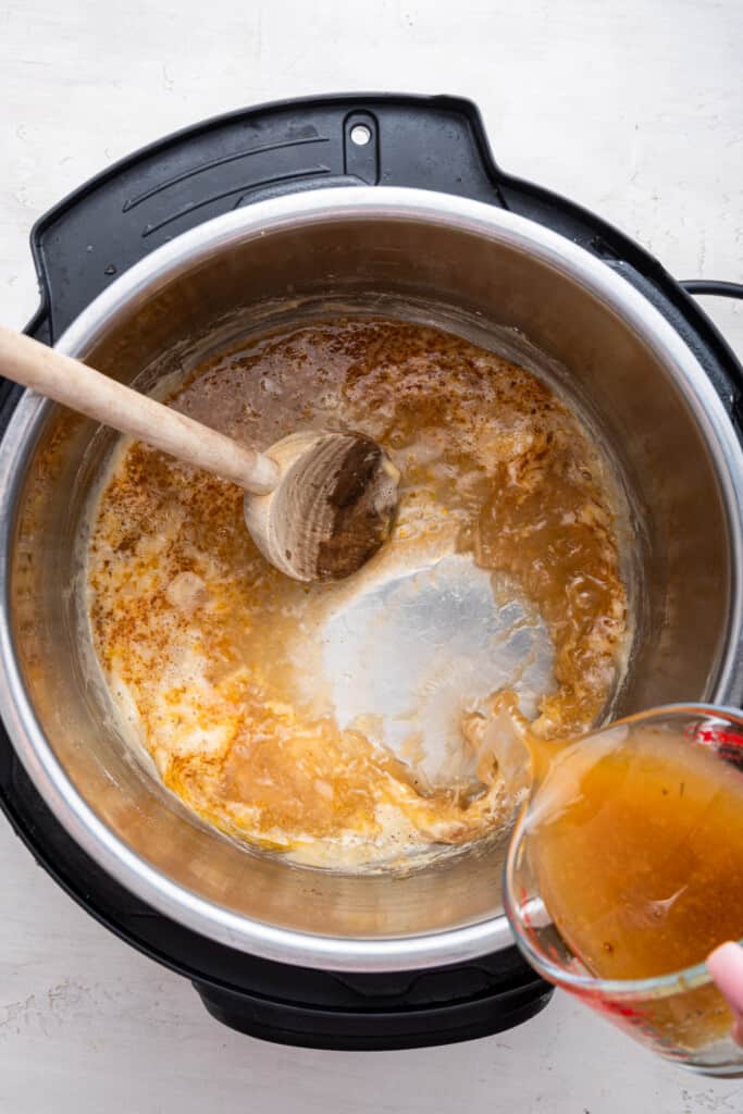 Overhead view of broth being poured into Instant Pot to make gravy