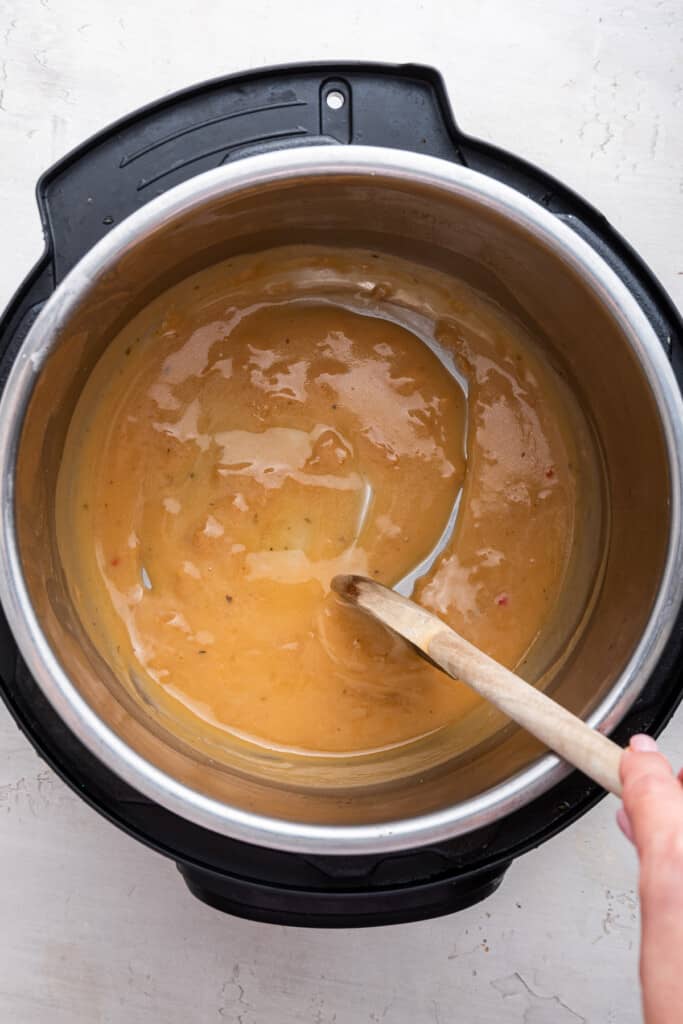 Overhead view of gravy being stirred in Instant Pot