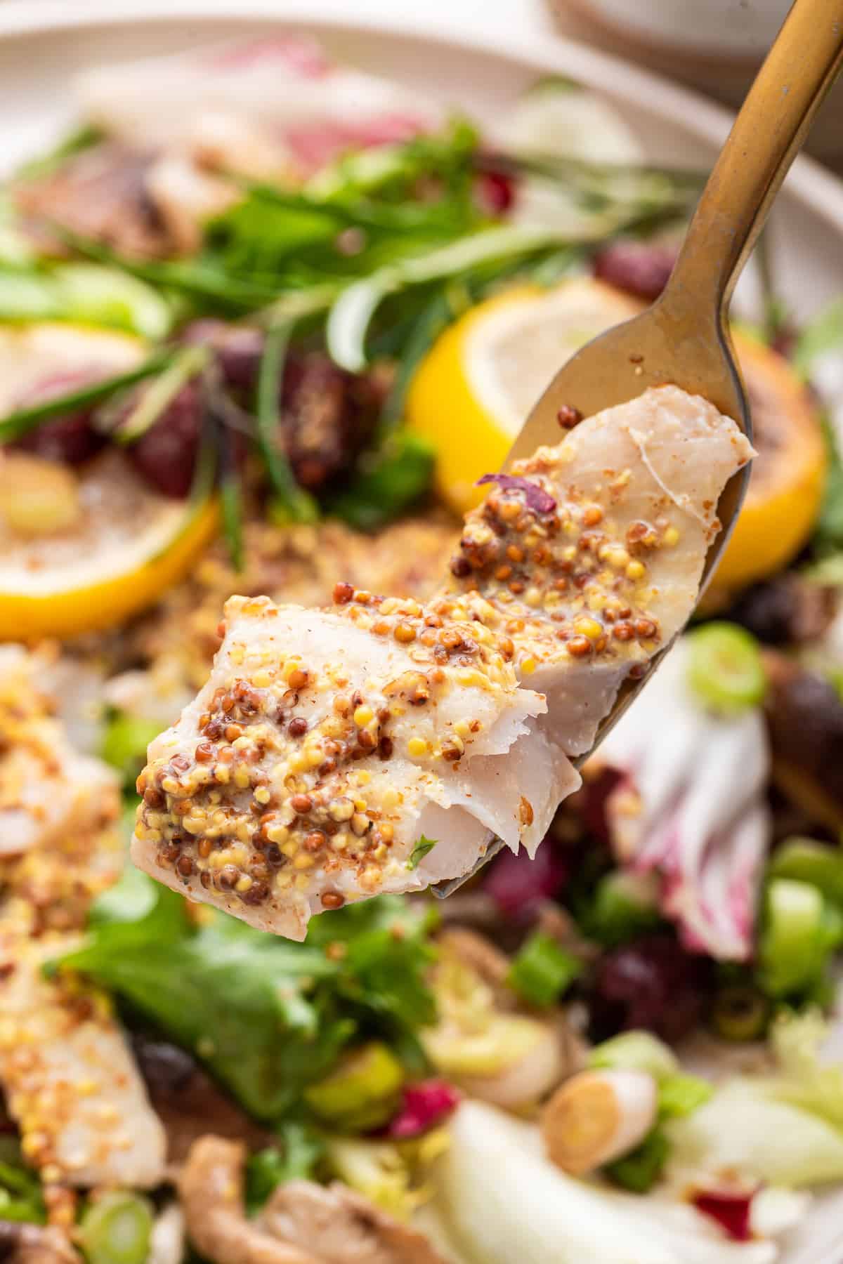 Fork holding bite of baked halibut