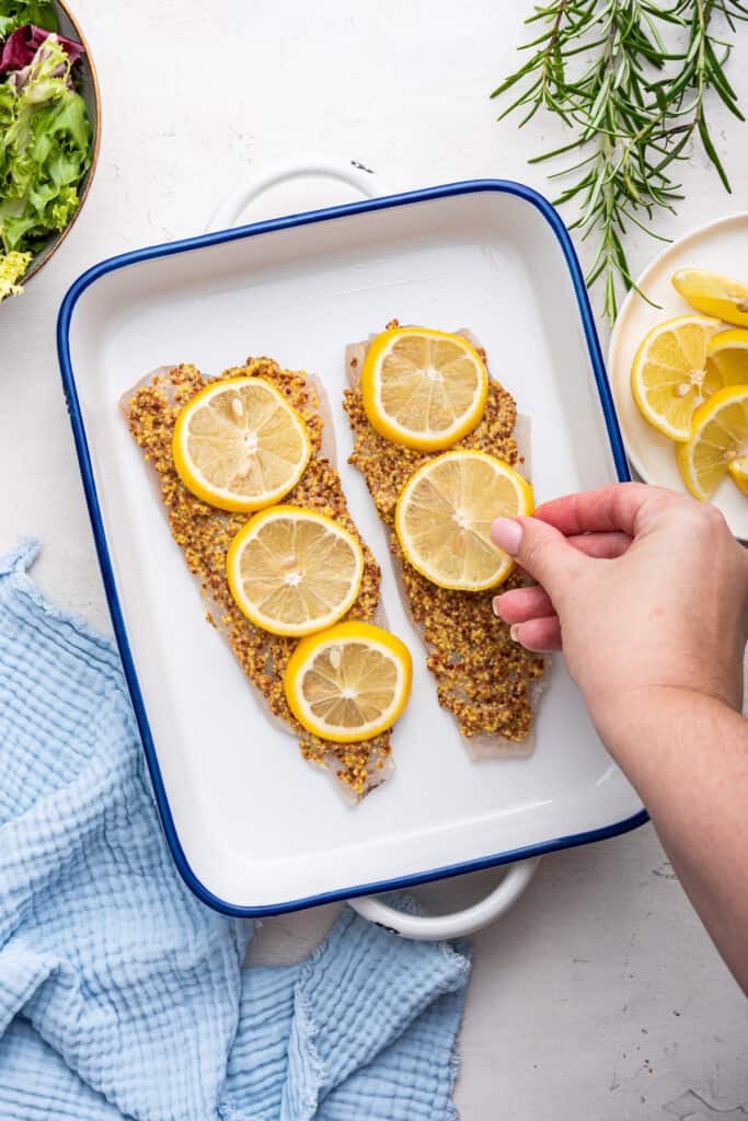 Overhead view of halibut topped with mustard and lemon slices