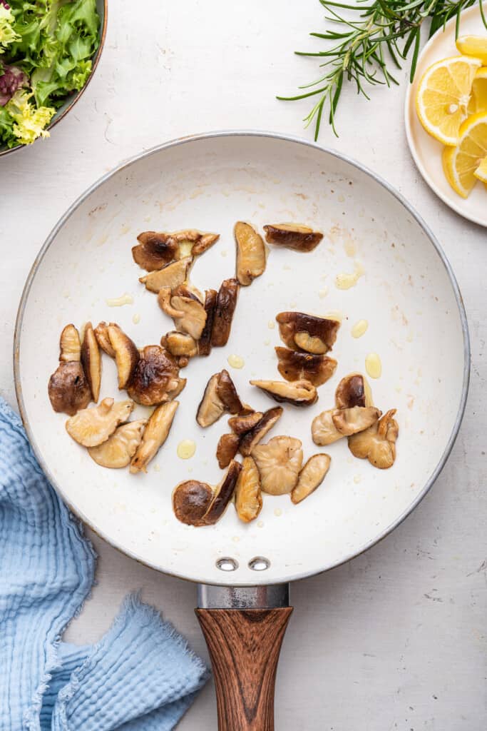 Overhead view of cooked shiitake mushrooms in skillet