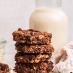 5 banana oatmeal cookies stacked on wire cooling rack