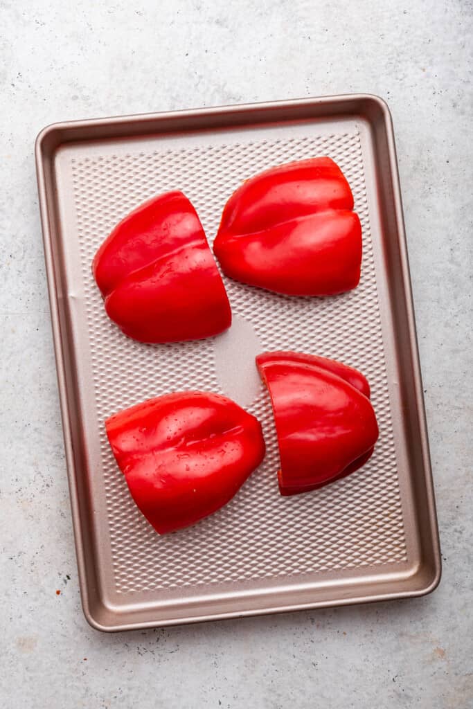 Red bell pepper halves on baking sheet