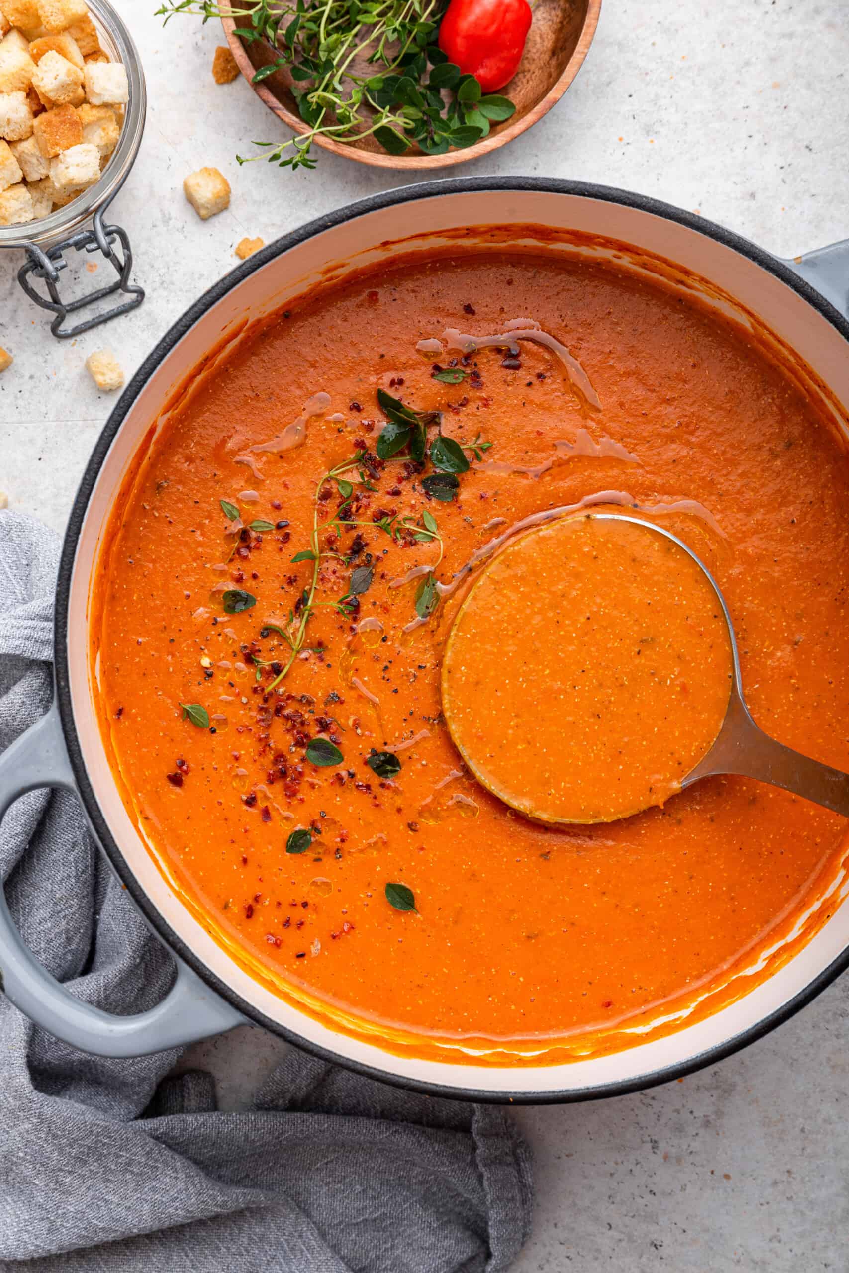 Dutch oven with ladle and roasted red pepper soup