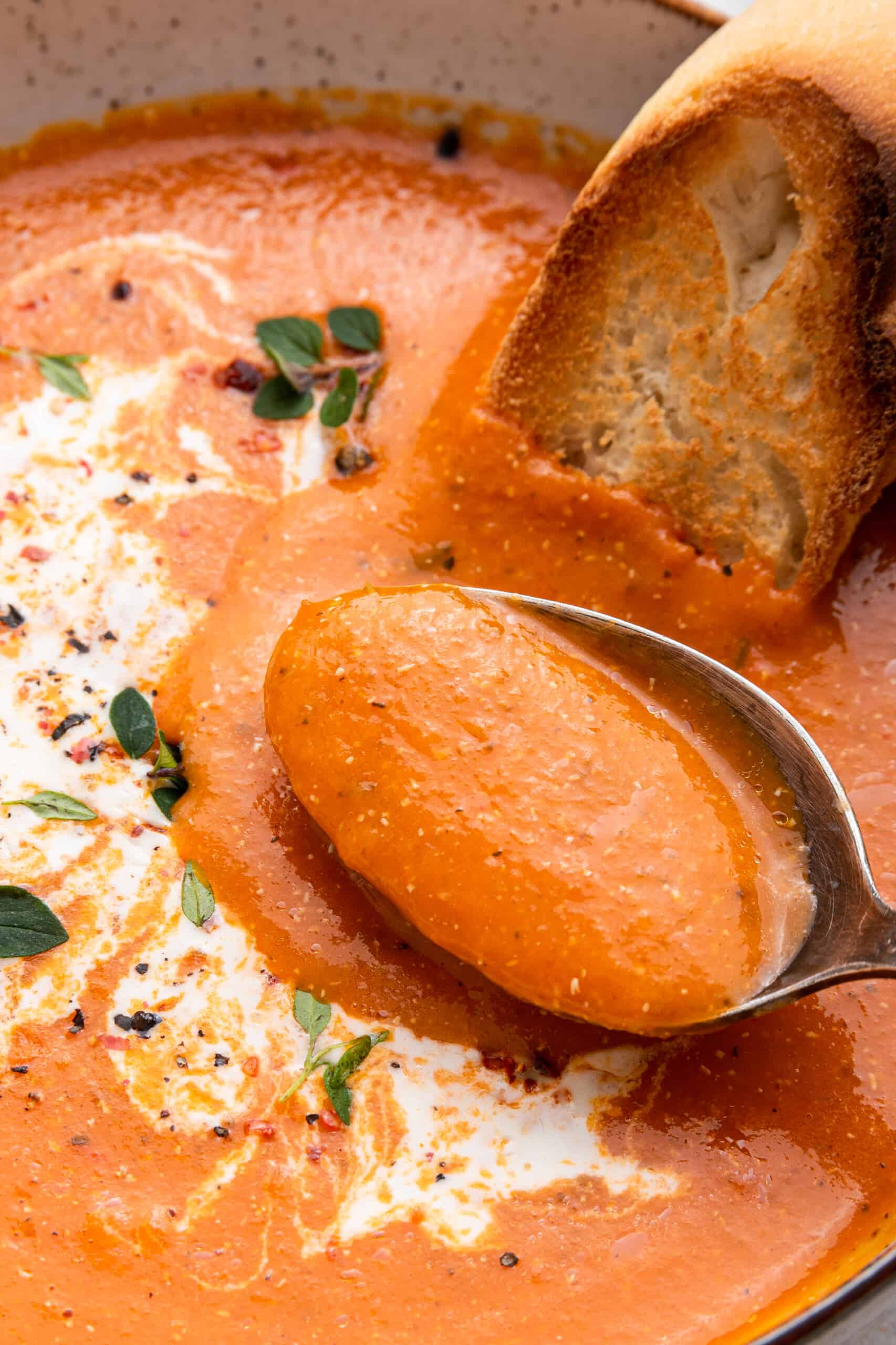 Spoonful of roasted red pepper soup in bowl