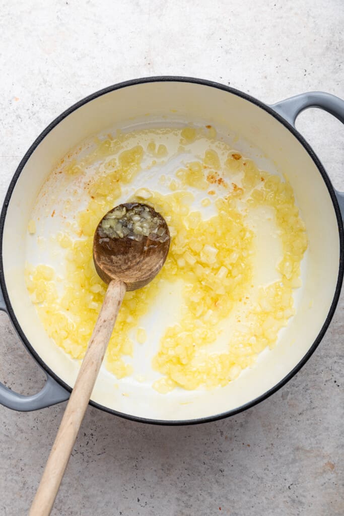 Sauteeing onions in Dutch oven with wooden spoon