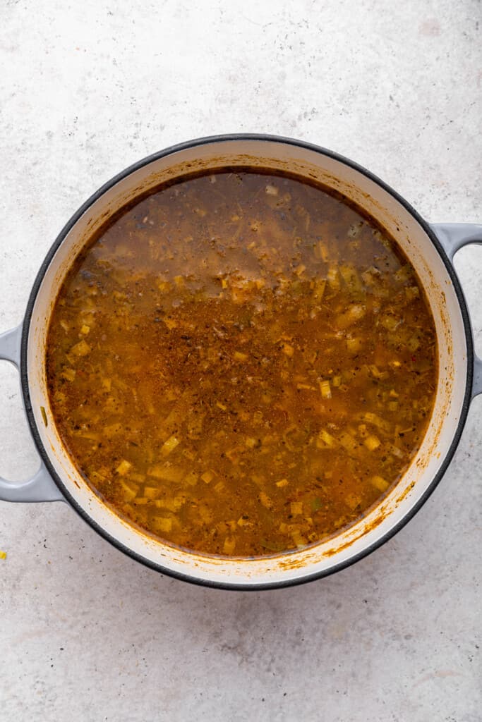 Overhead view of soup in pot after adding seasonings