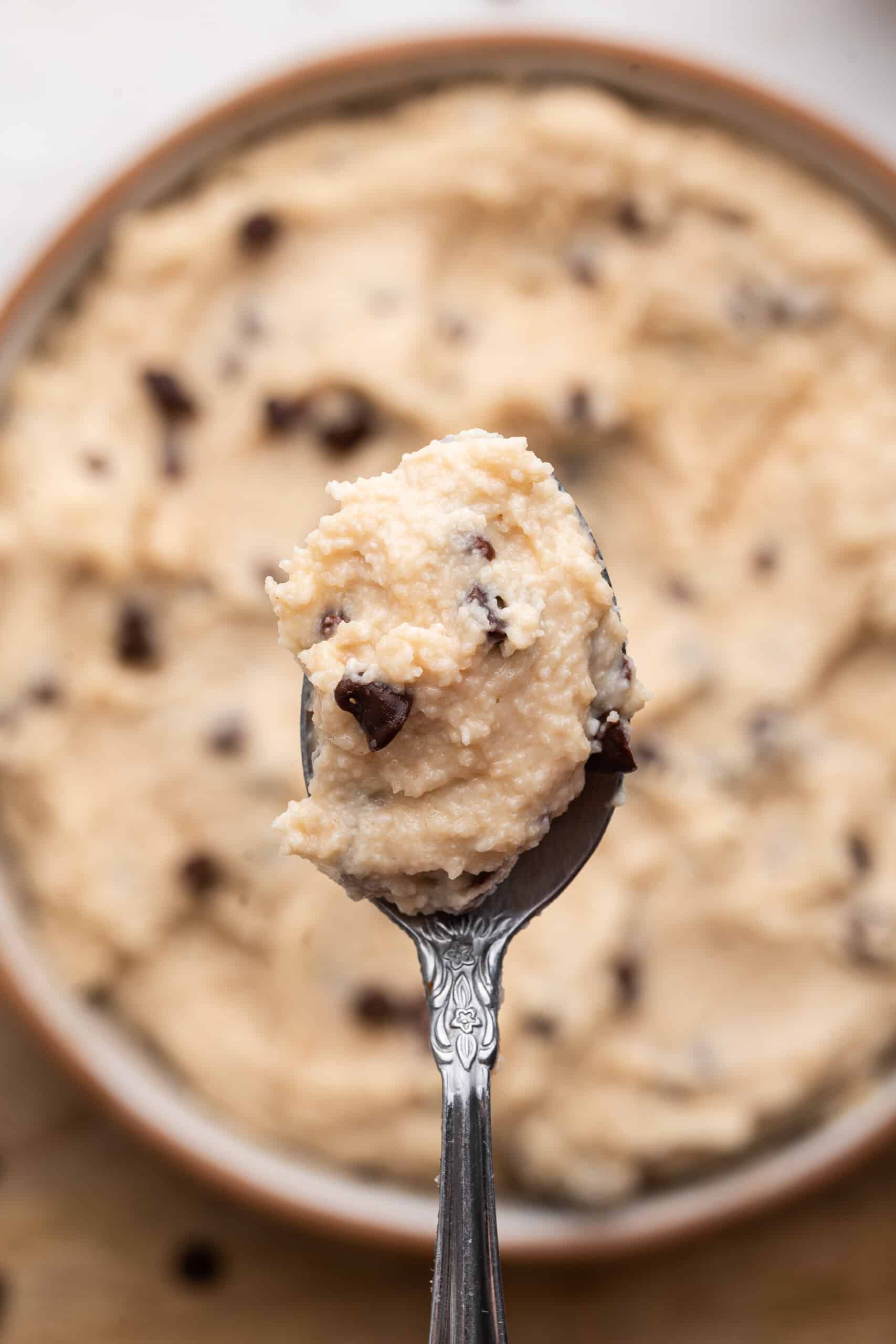 Spoonful of cottage cheese cookie dough held over bowl