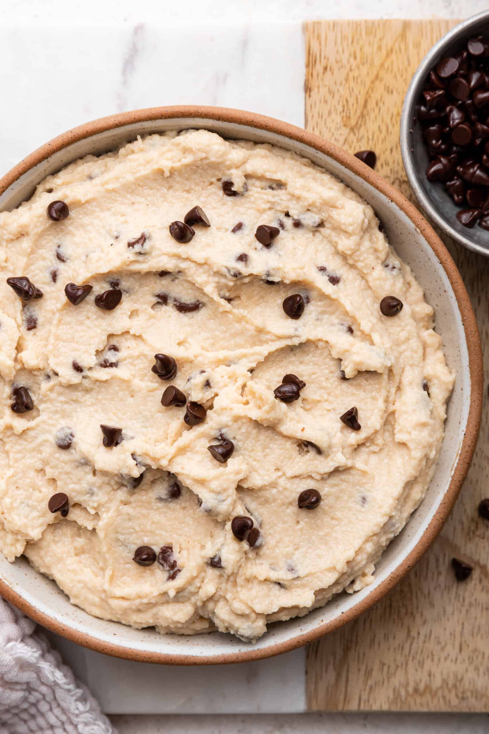 Overhead view of cottage cheese cookie dough in bowl with small bowl of chocolate chips