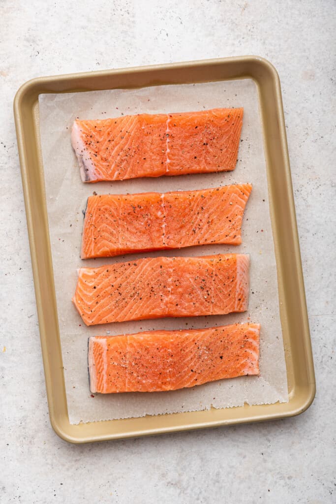 Overhead view of salmon fillets on sheet pan