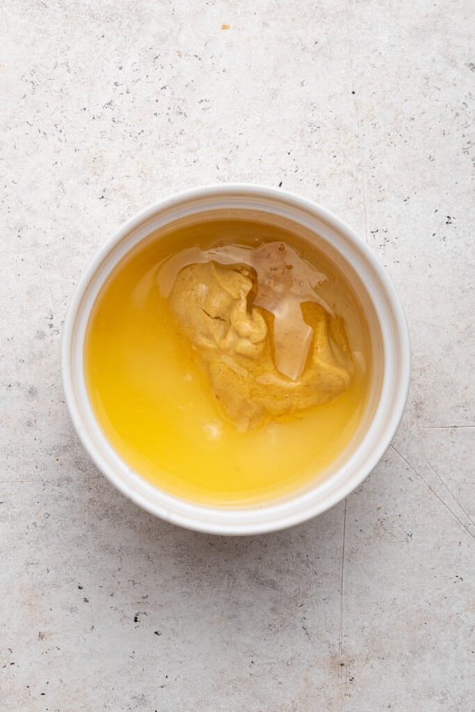 Overhead view of mustard, lemon juice, and honey in small bowl