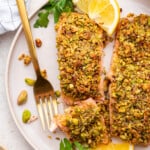 Overhead view of pistachio crusted salmon on plate with fork