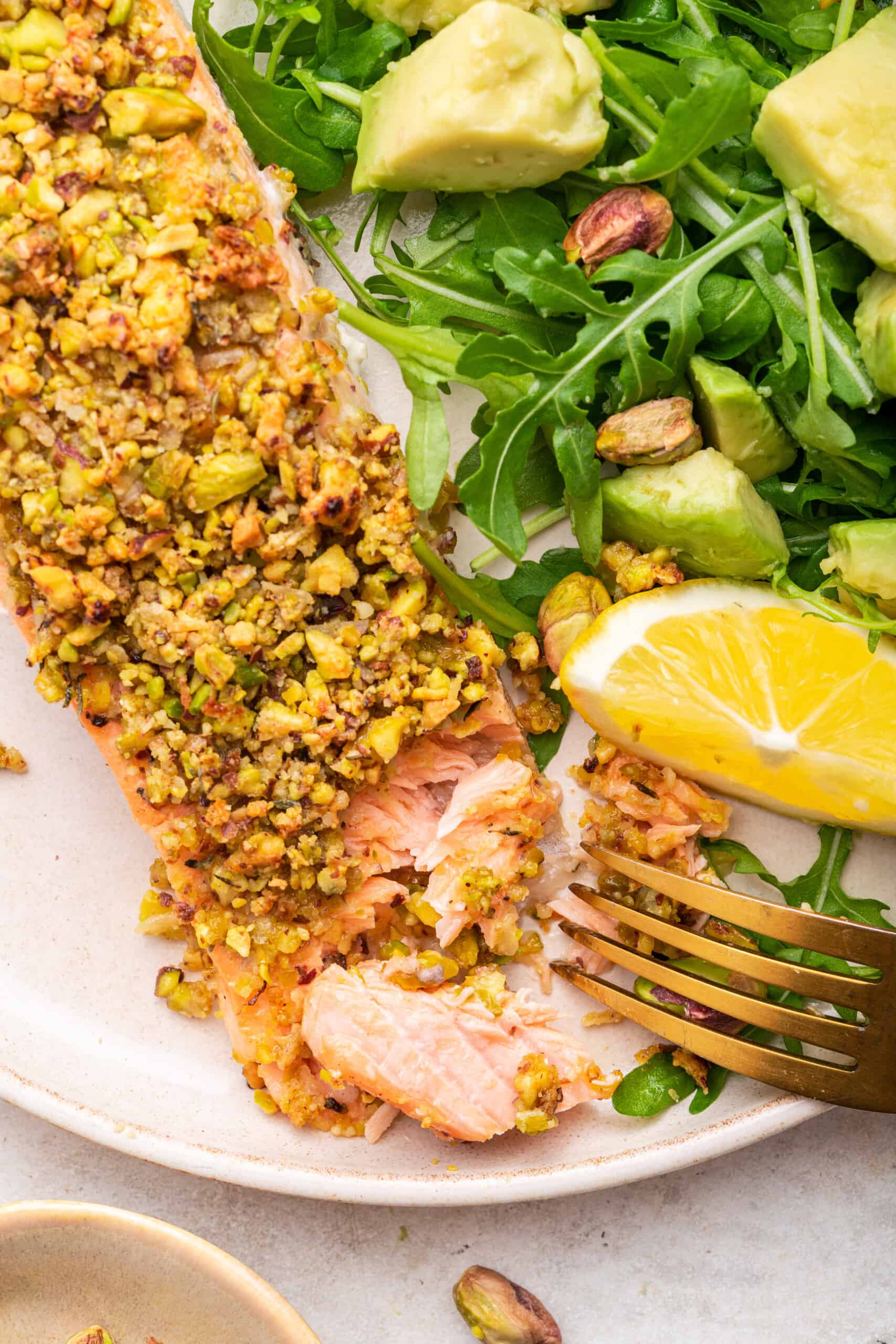 Overhead view of pistachio crusted salmon on plate with salad