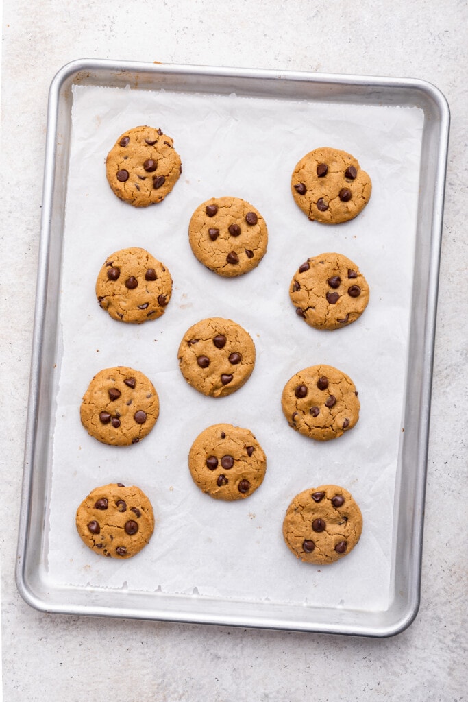 Overhead view of tahini chocolate chip cookies on parchment lined baking sheet
