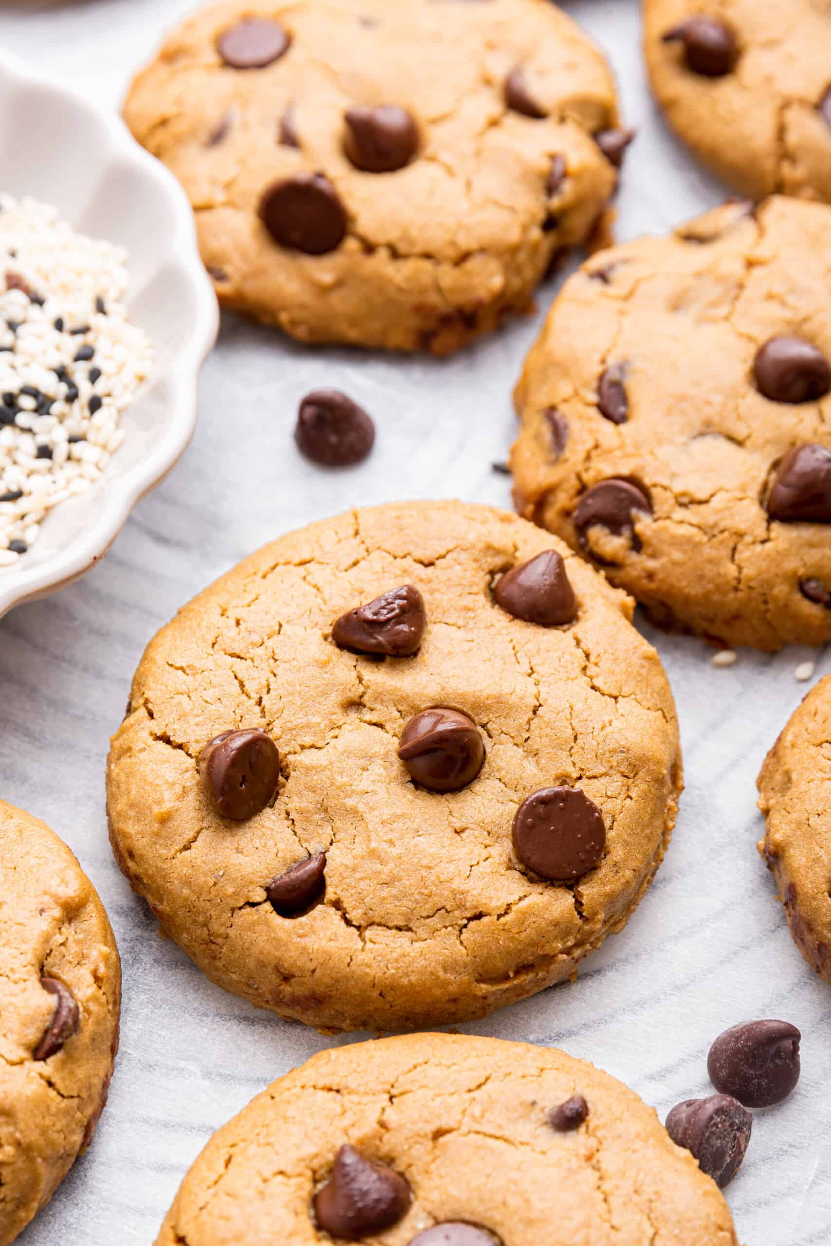 Vegan and gluten-free tahini chocolate chip cookies on parchment paper