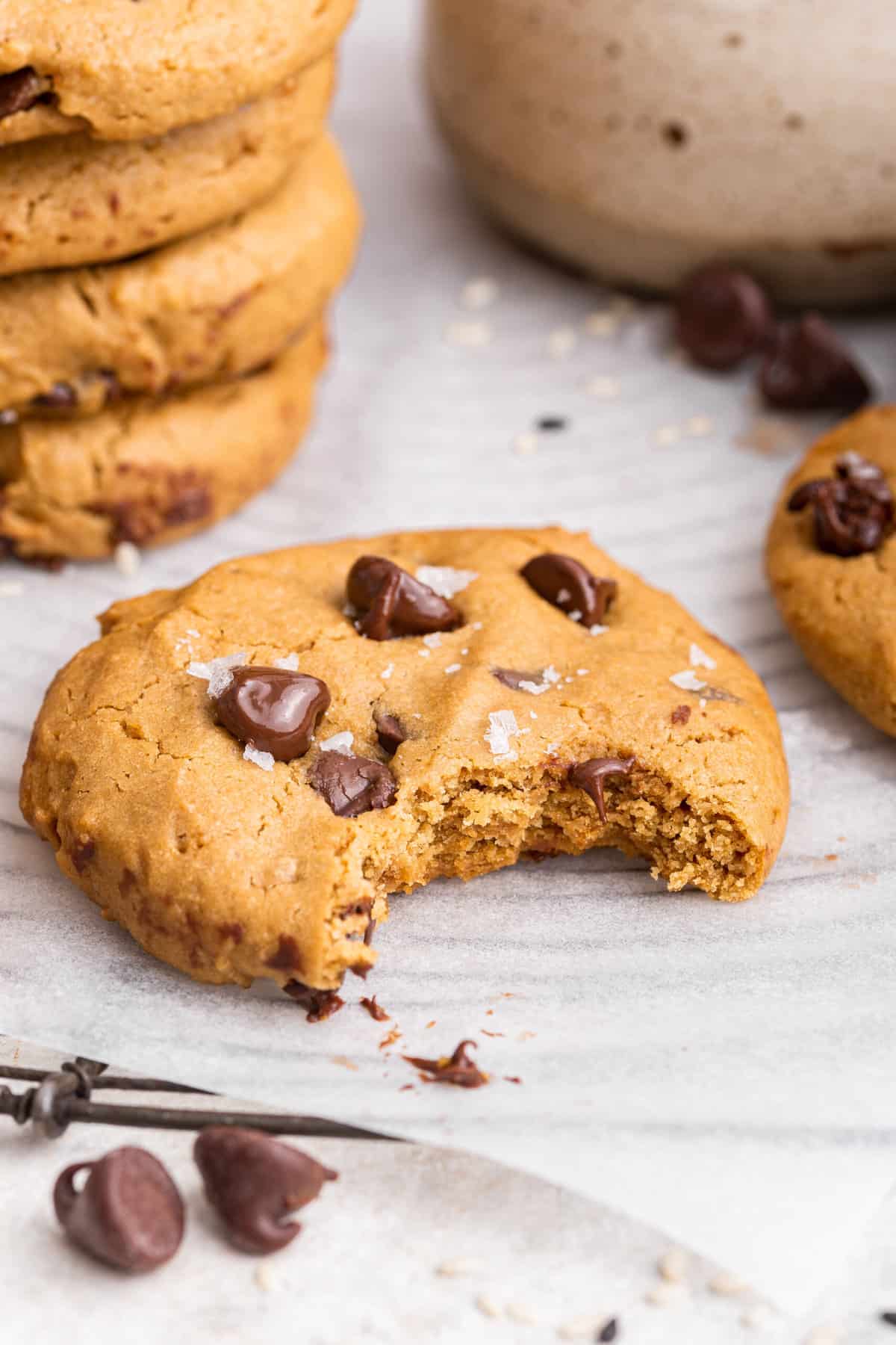 Tahini chocolate chip cookies might just be the best chocolate chip cookies you'll ever taste. They're vegan, gluten-free, and so delicious! Tahini chocolate chip cookie with bite taken out